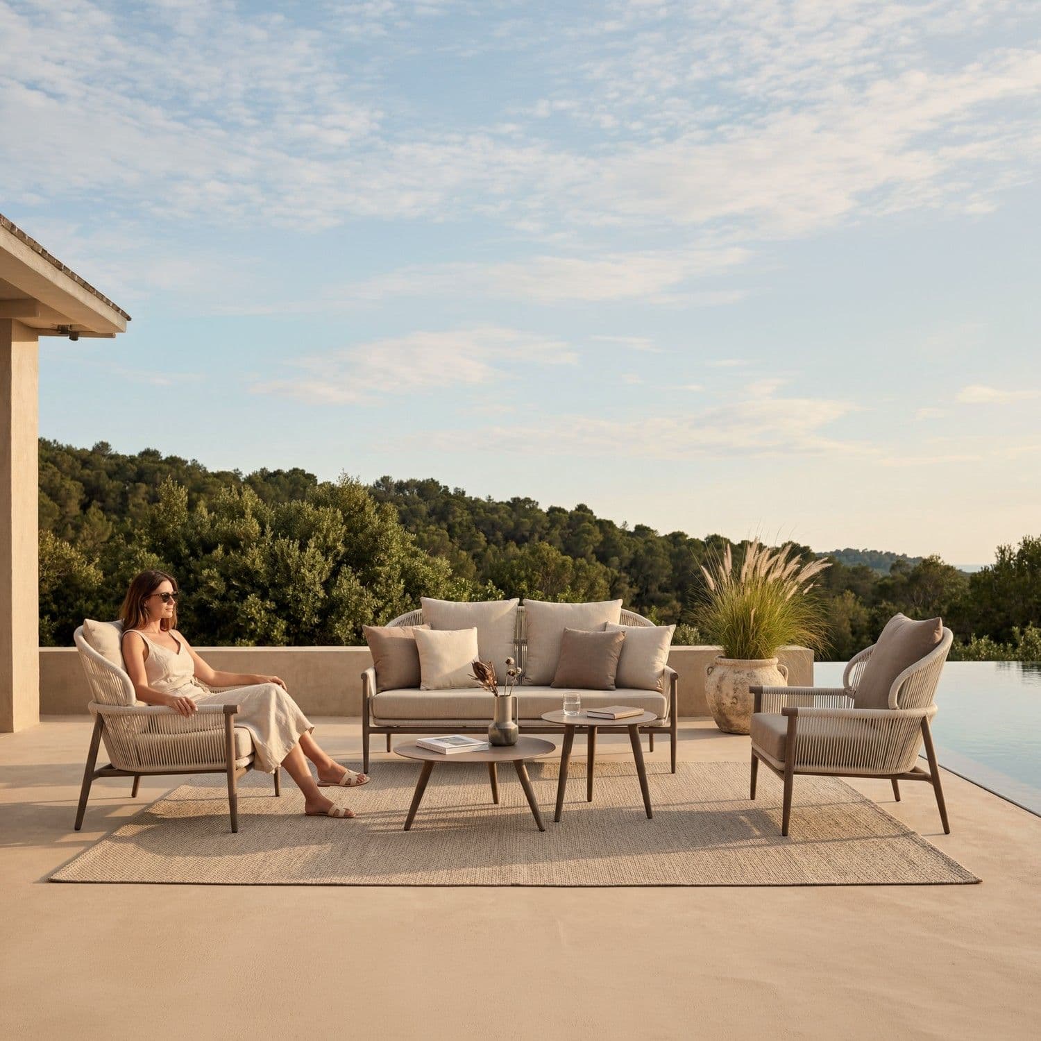 BLOOM Nest luxury outdoor lounge set on a serene poolside terrace. Premium woven chairs, sofa, and tables for exclusive outdo