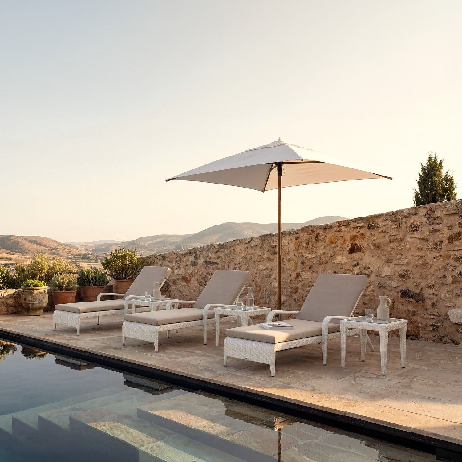 BLOOM Milan luxury woven sun loungers & side tables by a serene poolside terrace, perfect for designer outdoor living.