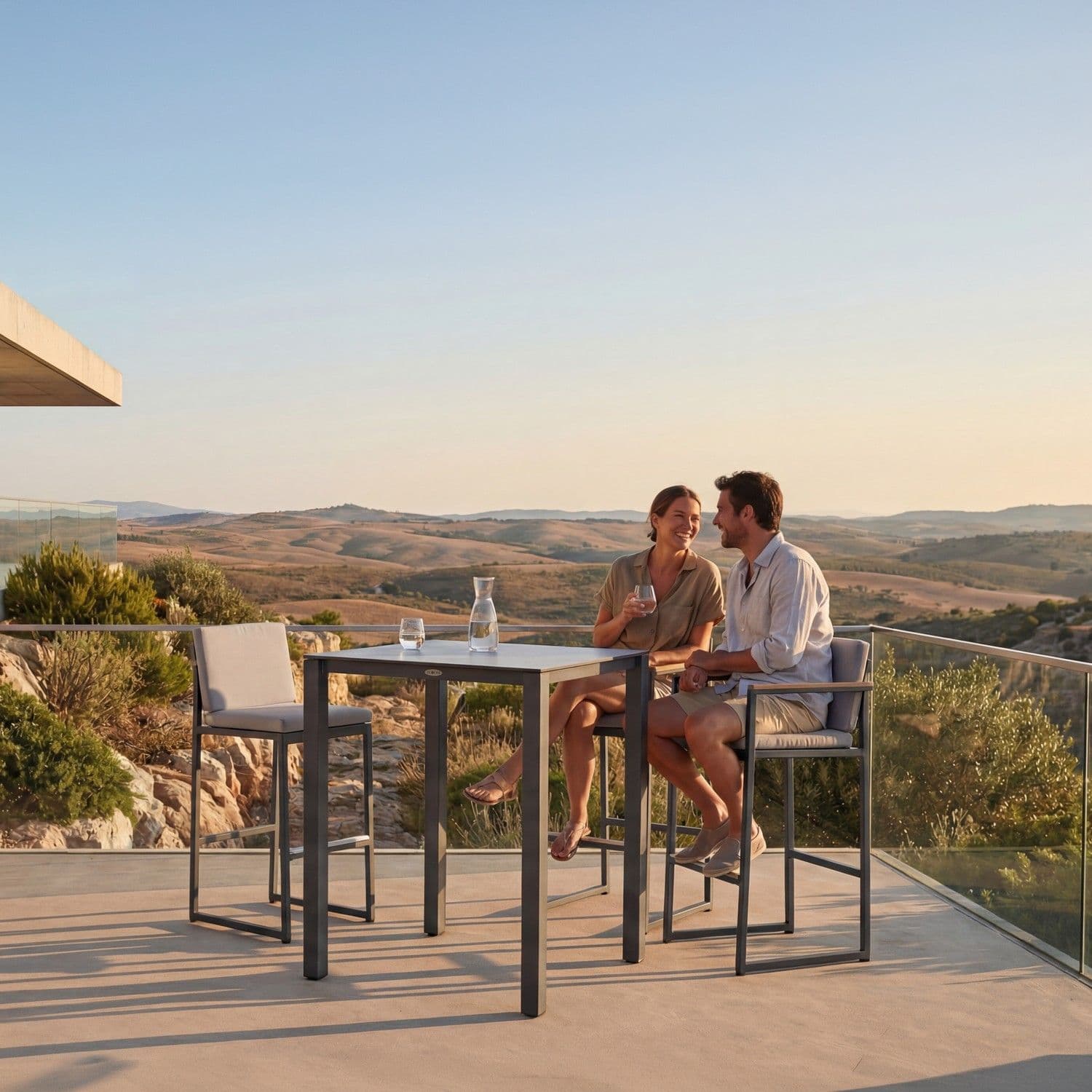BLOOM Elios luxury bar set on a designer terrace overlooking rolling hills at sunset. Premium aluminum, wood-look, and fabric